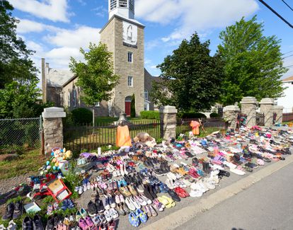 Flores y zapatos infantiles colocados frente a una iglesia en protesta tras el hallazgo de los restos de 215 niños en un orfanato.