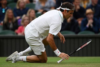 Federer cae sobre la hierba durante el partido contra Sonego.