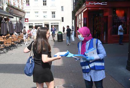 Una sanitaria ofrece un test rápido a una joven que pasea por Carnaby este lunes en Londres.