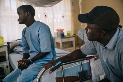Samuel Joseph, un enfermero de Médicos Sin Fronteras (MSF), habla con Bilya, un paciente de noma de 20 años, el día antes de su primera cirugía.