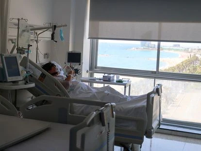 Un paciente con covid mira el móvil en una habitación del Hospital del Mar de Barcelona