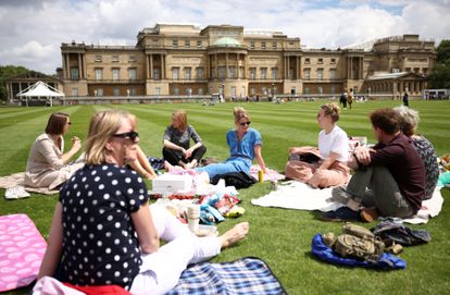 Un grupo de visitantes hace un picnic en el palacio de Buckingham, en Londres.