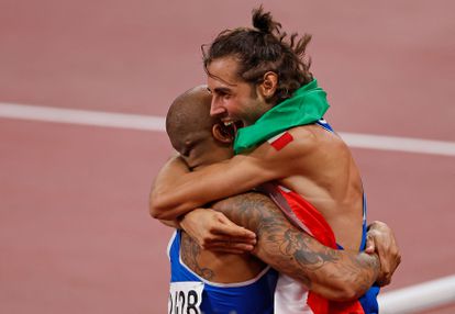 Jacobs se abraza con el otro medallista de oro italiano del día, el saltador Gianmarco Tamberi, momentos después de ganar la final de los 100m. 