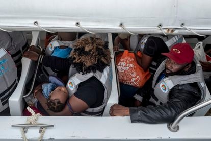 Migrantes haitianos embarcándose en el muelle.