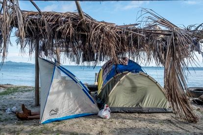 Un migrante descansa en una de las tiendas de campaña sobre la playa de Necoclí. 