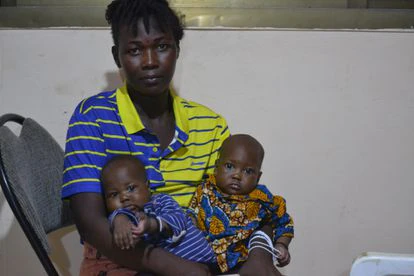 Umu Kamarah, junto a sus dos gemelos, que nacieron unas semanas después del incendio. Kamarah tuvo que huir de allí embarazada y, desde entonces, no ha podido regresar a su hogar.