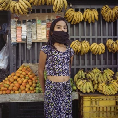 Elianny Toro, de 10 años, posa para un retrato frente al puesto de frutas de su papá en el centro de Caracas.