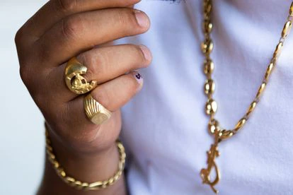 Los anillos, el collar y uña pintada con el signo del dolar.