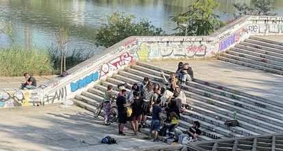 Jóvenes haciendo botellón, este sábado, en los márgenes del río Guadalquivir.