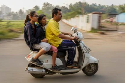 El doctor Rakh, su sobrina y su hija viajan en moto en dirección al parque donde hacen deporte todas las mañanas.