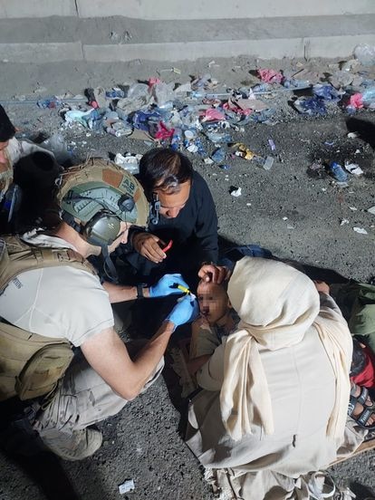 Un médico español atiende a un niño de un refugiado herido al entrar a la base.