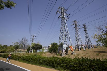 Un hombre camina junto a las torres eléctricas de una subestación eléctrica de Madrid, este miércoles.