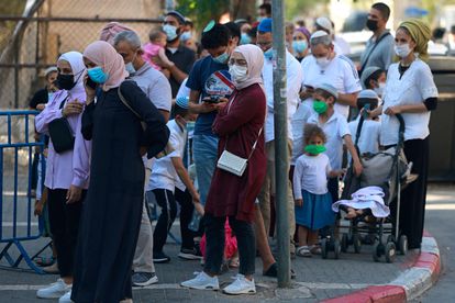 Un grupo de personas espera frente a un establecimiento médico donde hacen test rápidos, este domingo en Jerusalén.