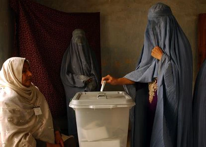 Una mujer afgana con burka mete su papeleta en una urna en Kabul en 2004, en las primeras elecciones presidenciales del país.