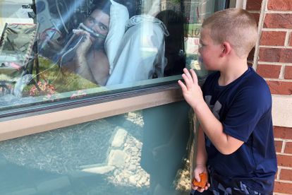 Un niño mira a su padre ingresado por covid en un hospital del Estado de Misuri, EE UU.