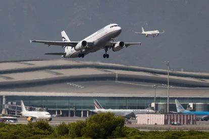 Un avión despega mientras otro aterriza simultáneamente en el aeropuerto de El Prat.