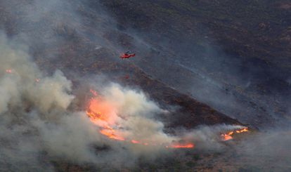 Un helicóptero intentan extinguir el incendio de Sierra Bermeja, este lunes. 