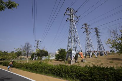 Una persona pasa cerca de varias torres eléctricas, en Madrid.