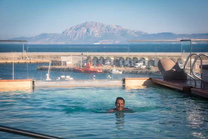 Un turista nada en la piscina del hotel La Residencia Puerto.