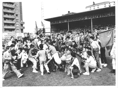 Aficionados de la SD Eibar rodean en el césped del estadio de Ipurua a los jugadores del club en una imagen de archivo.