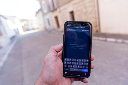 Un paseante muestra su teléfono sin cobertura en una calle de Castronuevo de Esgueva.

