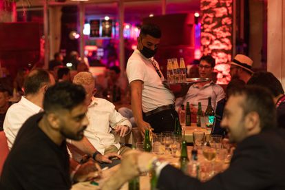 Un camarero sirve a clientes de una discoteca del paseo marítimo de Barcelona, el 23 de septiembre.