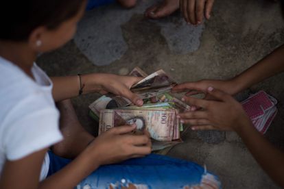 Un grupo de niños juegan con billetes no utilizados de bolívares en Venezuela, el 9 de septiembre.