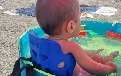 Higinio, un niño de un año con problemas de movilidad, se baña en una piscina sentado en un asiento postural de Fiixit.