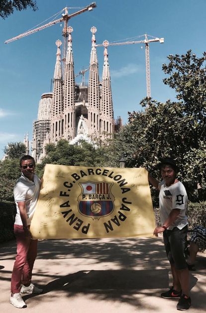 Hiroki Nakano (izquierda), presidente de la  Penya FC Barcelona Japan, posta con una bandera delante de la Sagrada Familia.