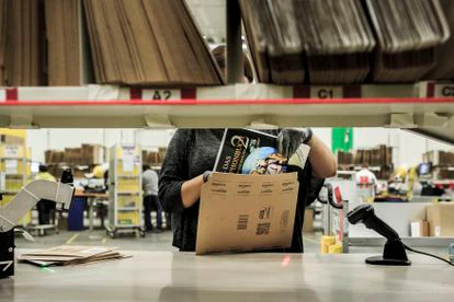 Una empleada de Amazon introduce un libro para su envío en los almacenes de la compañía en Brieselang, Alemania.
