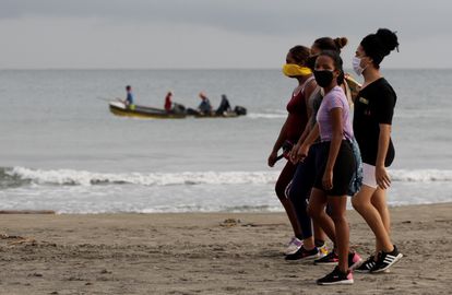 Un grupo de personas con mascarilla camina en una playa de Cartagena (Colombia).