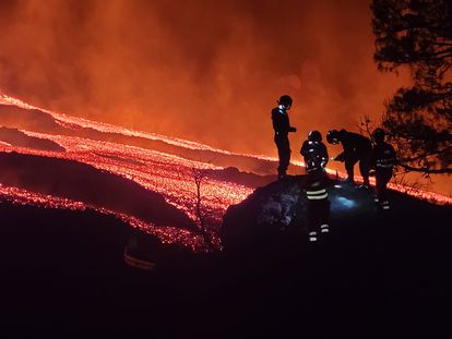 Cinco miembros de la Unidad Militar de Emergencias recogen muestras de lava en el volcán de La Palma.