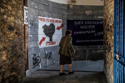Una mujer camina por una calle de Hernani (Gizpuzkoa) con pintadas de apoyo a los presos de ETA.