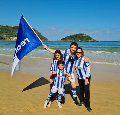 Jose Carrasco y Laura Jiménez, con sus hijos Iraia y Urko, en la playa de la Concha, vestidos de la Real Sociedad.