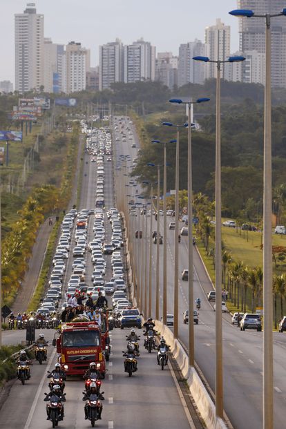 Un camión del Departamento de Bomberos lleva el ataúd de la cantante Marília Mendonça seguido de docenas de autos en Goiânia, Brasil. 