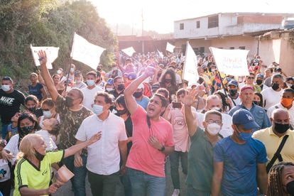 El candidato por la Mesa de la Unidad, José Manuel Olivares, saluda a unos simpatizantes mientras camina junto al excandidato a la gobernación de Miranda, Carlos Ocariz,  en La Guaira, Venezuela, el 14 de noviembre.