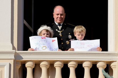 El príncipe Alberto de Mónaco junto a sus hijos, Gabriella y Jacques, que sostienen sendos carteles con mensajes de apoyo a la princesa Charlène, este viernes en el Día Nacional del Princiado.