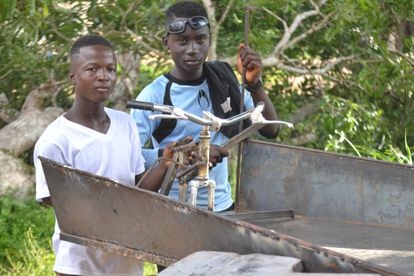 Hassan y Cyrus, dos chavales que han vivido muchos años en las calles de Sierra Leona y ahora aprenden a cómo fabricar cosas a partir de la chatarra con Emiliano y su carrusel.
