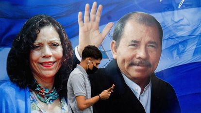 Un hombre revisa su teléfono frente a una pancarta que promueve al presidente nicaragüense Daniel Ortega y a la vicepresidenta Rosario Murillo el 25 de septiembre de 2021.