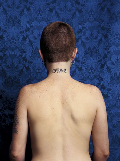 Una mujer con la palabra 'Bollera' tatuada en el cuello.