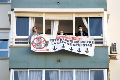 Los vecinos de Carlos Haya, 65, en Málaga, descuelgan la pancarta en contra de la apertura de una casa de apuestas en los bajos, tras conseguir que ese negocio no se instale allí.