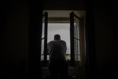 Una persona se asoma a su ventana durante el primer día laborable de la segunda semana desde que se decretó el estado de alarma.
