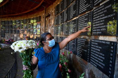 María de La Paz Chicas coloca flores en el área dedicada a los niños que fueron asesinados durante la masacre de El Mozote, en noviembre de 2021.