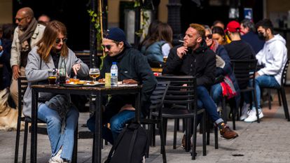 Una persona fuma en la terraza de un bar, en la plaza de Santa Ana de Madrid.