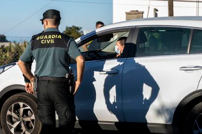 Un Guardia Civil conversa con una mujer en el dispositivo policial puesto en marcha para controlar el regreso a los domicilios de evacuados, este lunes en La Palma.