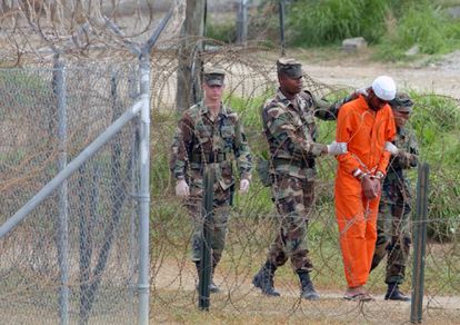 Policías militares trasladan a un detenido en la prisión de Guantánamo 
 (Cuba), el 6 de febrero de 2002. 