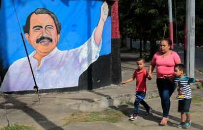 Una mujer pasea con sus hijos delante de un mural de Daniel Ortega este lunes en Managua.
