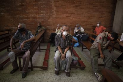Un grupo de personas espera para recibir alimentos gratuitos en una iglesia de Caracas en mayo de 2020.