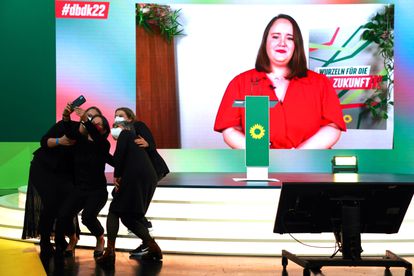 Afiliados de Los Verdes se hacían una foto con la nueva colíder del partido, Ricarda Lang, en la pantalla posterior, durante el congreso telemático celebrado este sábado.