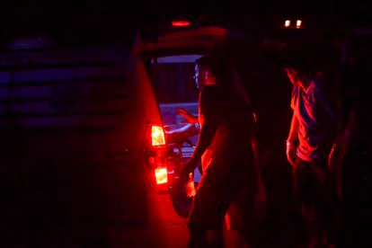 Un familiar de Cristina Aranda se encuentra junto a la ambulancia que la lleva al hospital luego de recibir un disparo. 